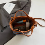 Women handbags. Early autumn senior commuter niche mobile phone slung bag girl 2025 new retro brown bucket bag small handbag